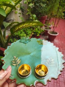 Handcrafted 8-inch aqua green resin Rakhi thali with top flower motif and bottom golden katoris