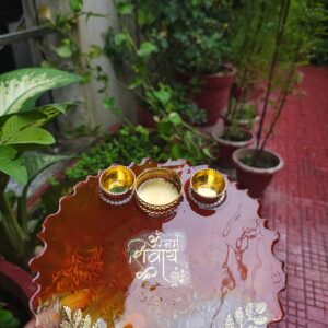 Handcrafted 8-inch amber red resin Rakhi thali with Om Namah Shivay inscription, embedded rice grains, and golden katoris