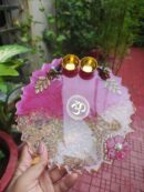Handcrafted 8-inch deep pink and clear Om resin Rakhi thali with embedded rice grains and golden katoris