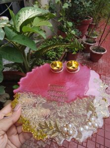 Handcrafted 8-inch coral pink and clear resin Rakhi thali with Vakratunda Mahakaya mantra and embedded rice grains