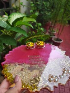 Handcrafted 8-inch deep pink resin pooja thali with Ganesh Mantra shloka, embedded rice grains, and golden katoris