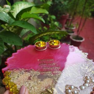 Handcrafted 8-inch deep pink resin pooja thali with Ganesh Mantra shloka, embedded rice grains, and golden katoris